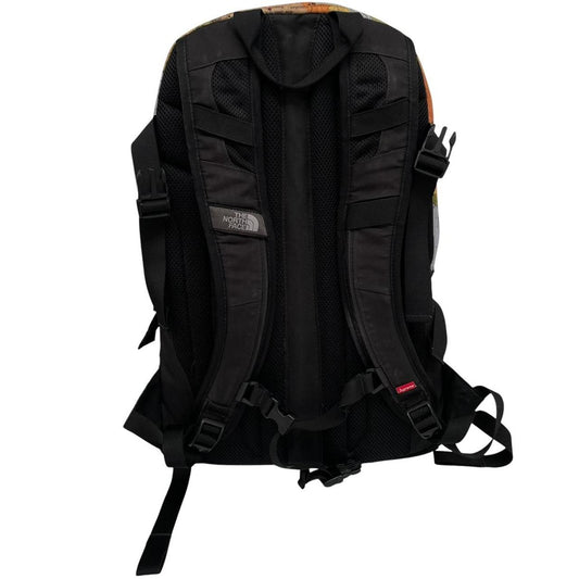 Supreme x The North Face black and multicoloured backpack with logo and scuffed base.