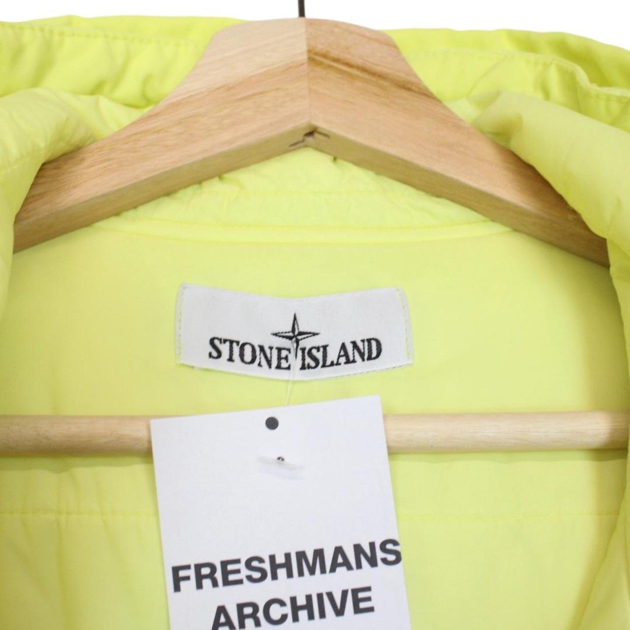 Stone Island yellow jacket with crinkle texture and logo badge on sleeve.