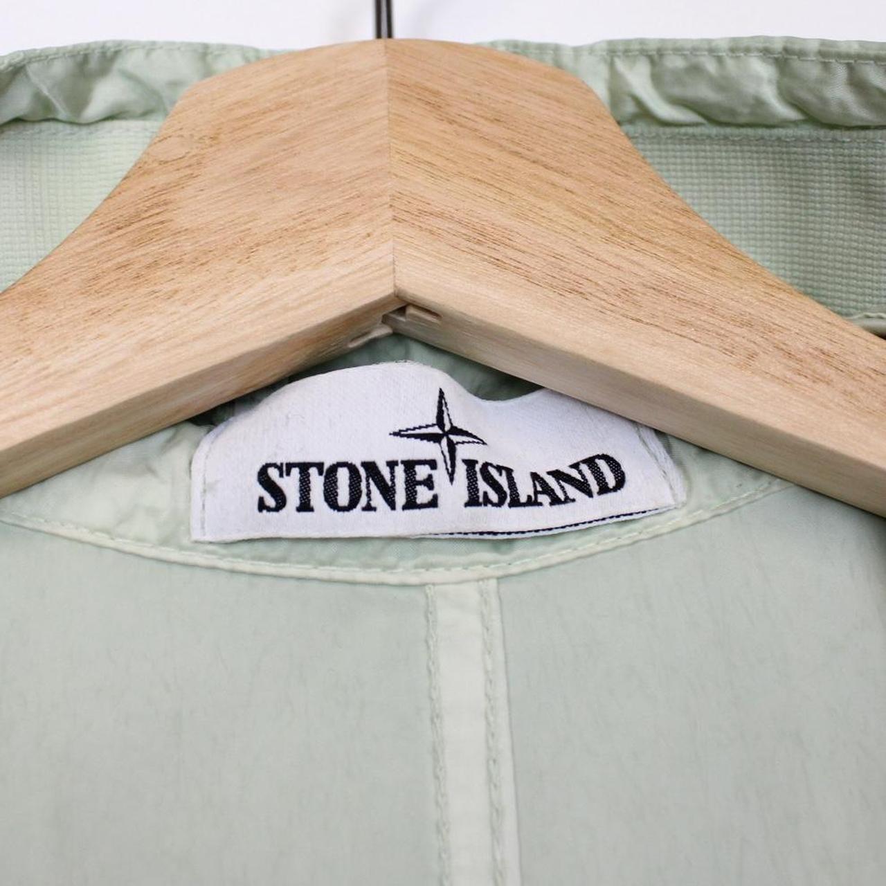 Stone Island mint green multi pocket jacket with logo patch and nylon material.