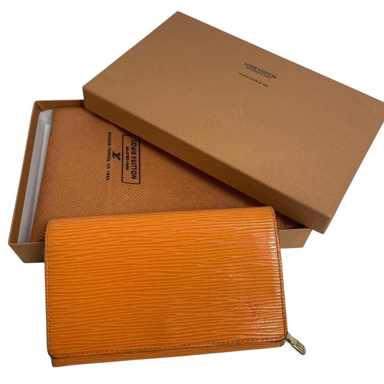Louis Vuitton orange leather wallet with Epi texture and embossed logo detail.