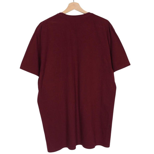 Stüssy burgundy pocket t-shirt with yellow college print and faint shoulder mark.