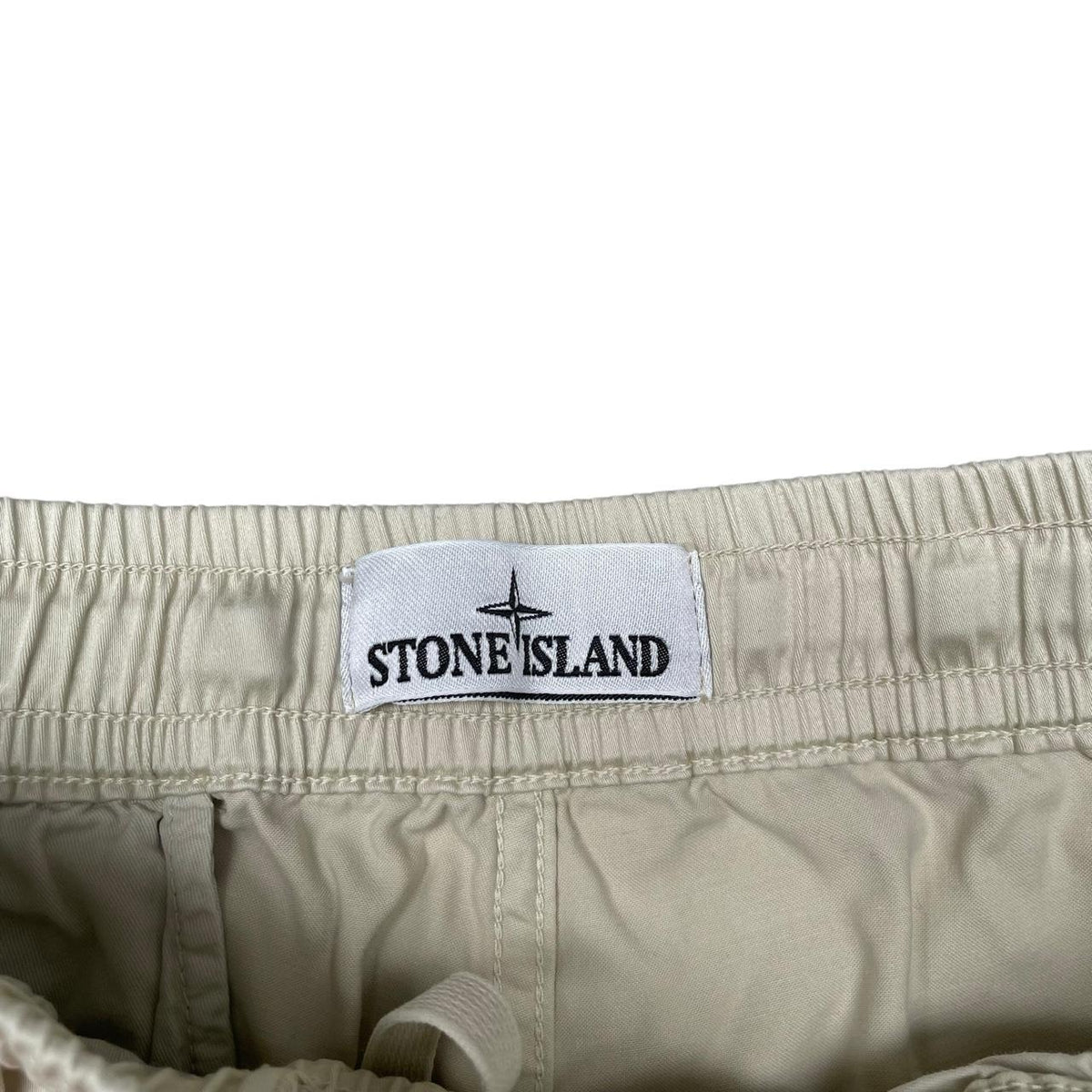 Stone Island beige cargo shorts with logo patch and multiple pockets.