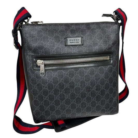 Gucci black duffel bag featuring GG Supreme monogram pattern and adjustable strap.