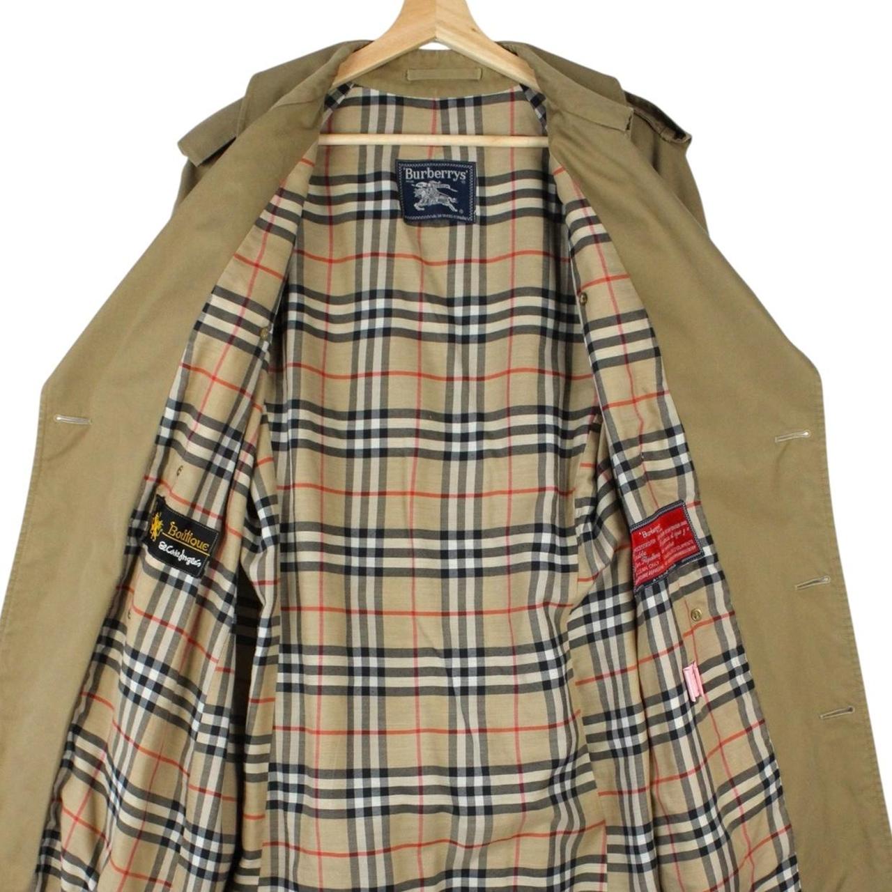 Burberry brown double breasted belted trench coat with classic check lining and logo details.
