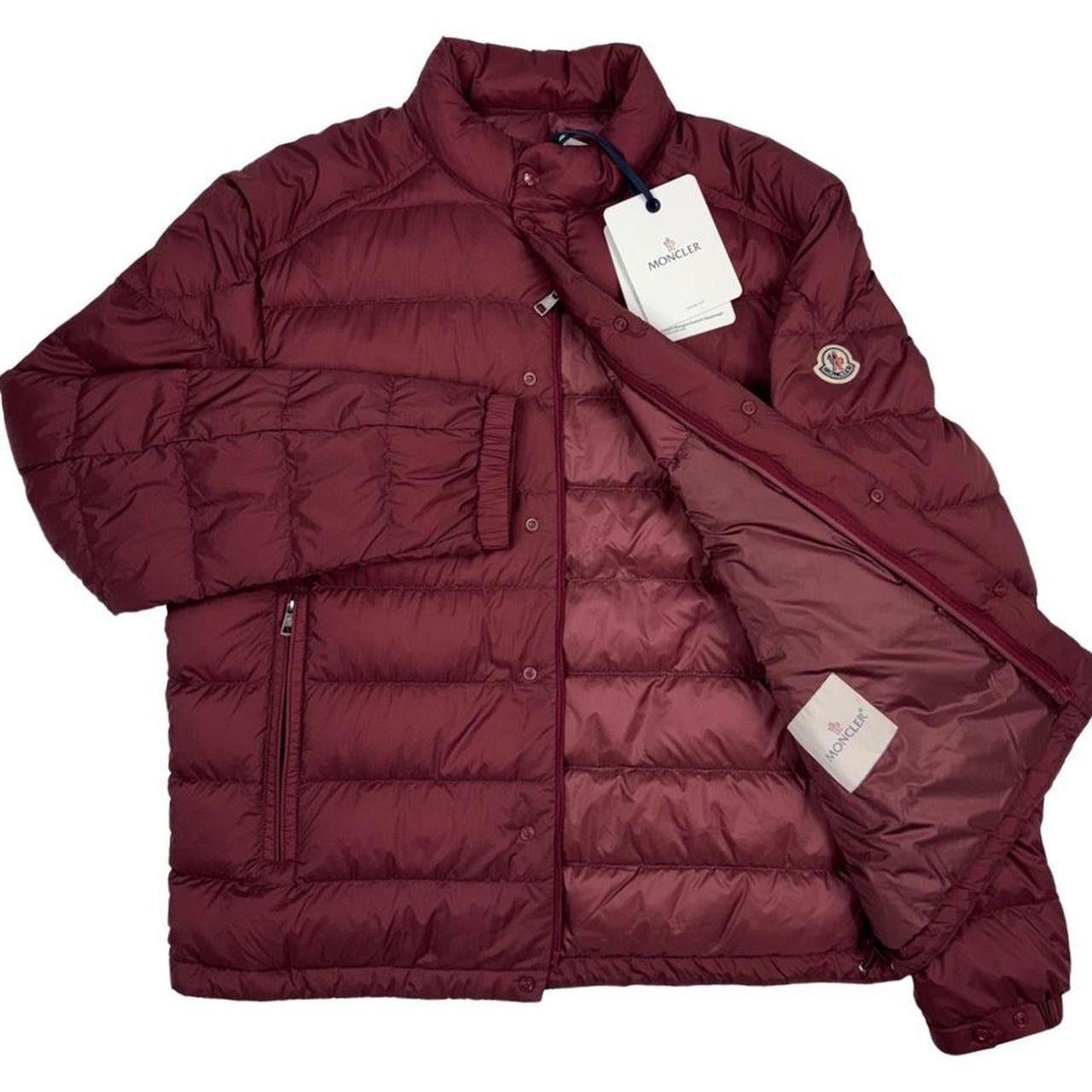 Moncler burgundy quilted down jacket with logo patch and shell material.