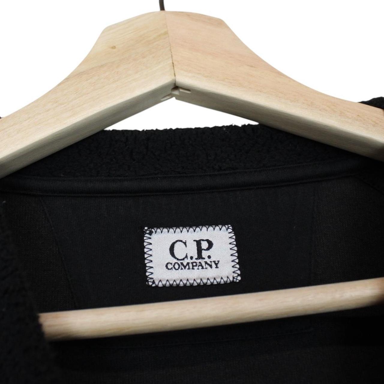 CP Company black fleece jumper with raglan sleeves and iconic lens detail.