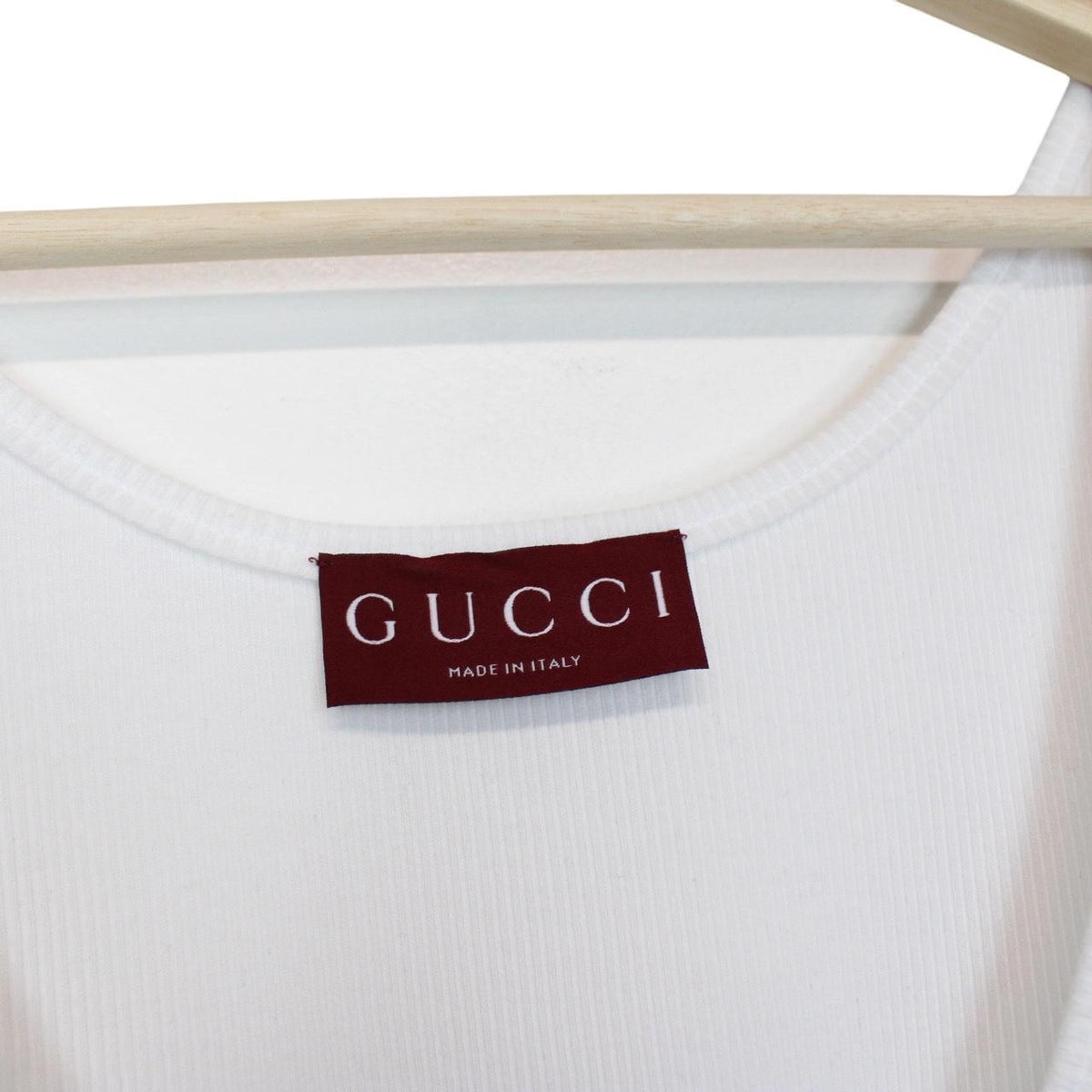 Gucci white tank top featuring bold logo print on soft cotton material.