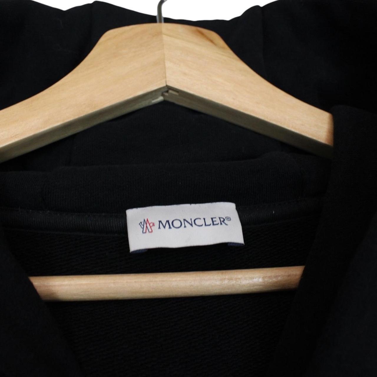 Moncler black hoodie jumper featuring logo patch and cotton material.