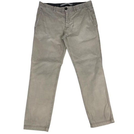 Stone Island beige slim fit cotton trousers with logo patch and visible wear marks.