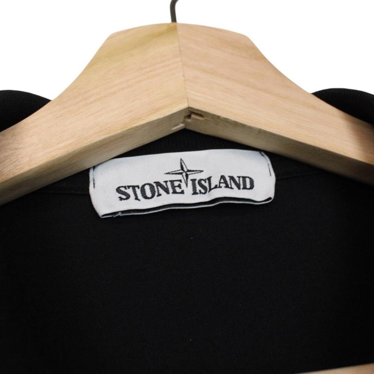 Stone Island black polo shirt with embroidered compass logo and cotton material.