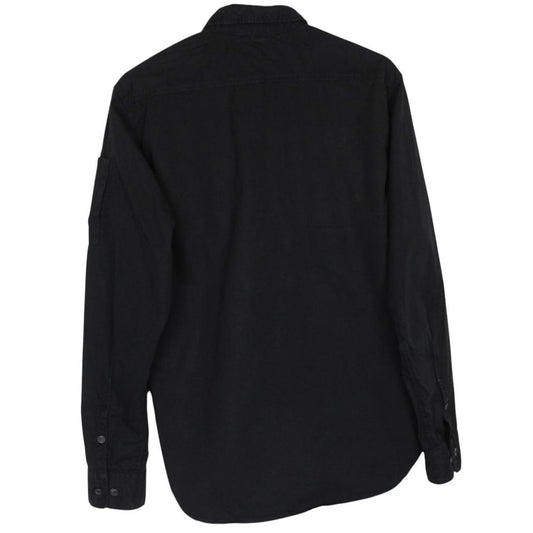 CP Company black button-up jacket with lens detail and cotton material.