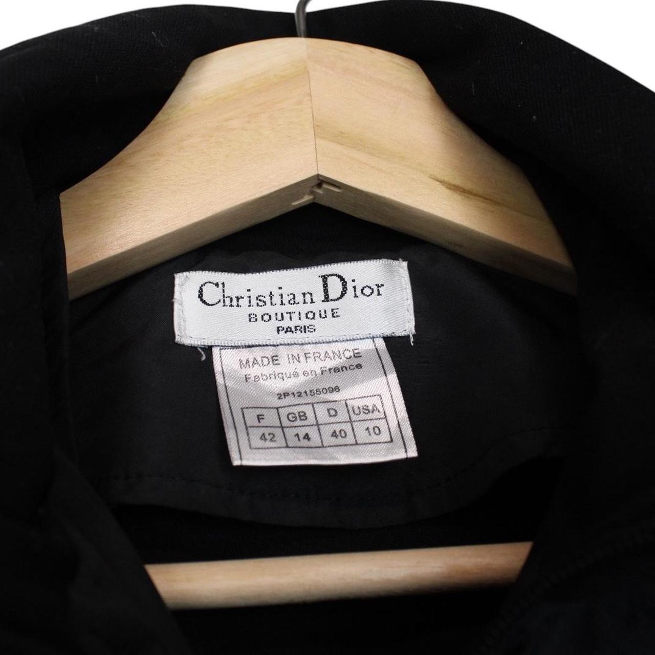Christian Dior black and yellow jacket with 'Remove Before Flight' graphic detail.