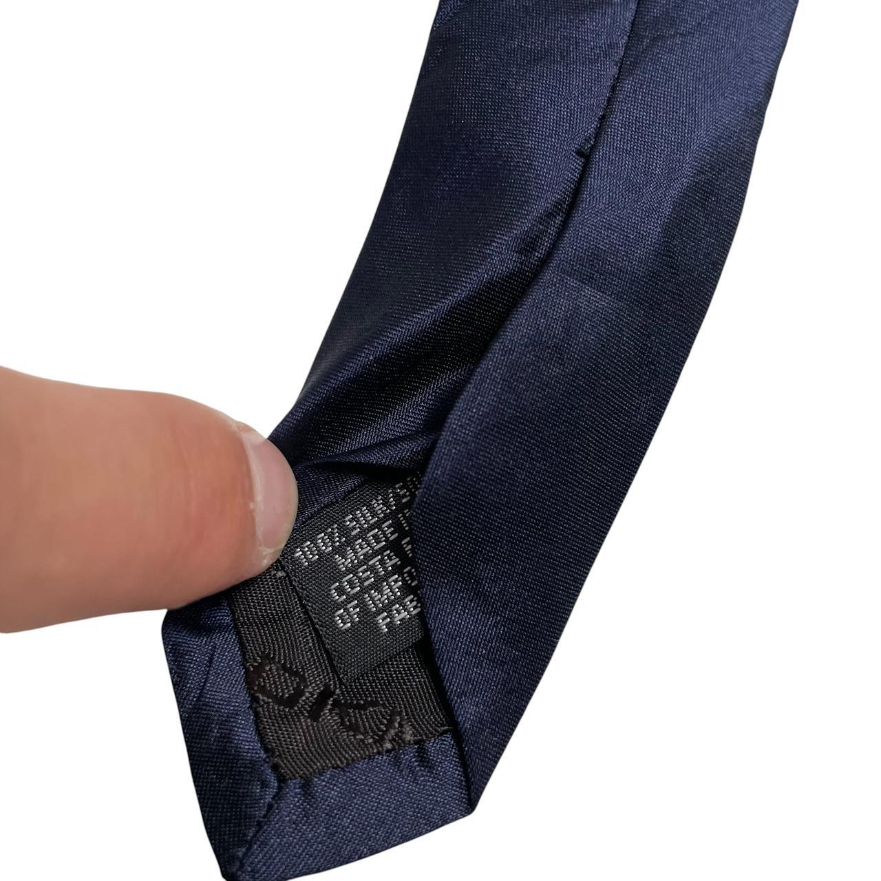DKNY navy blue silk tie with subtle sheen and classic design.