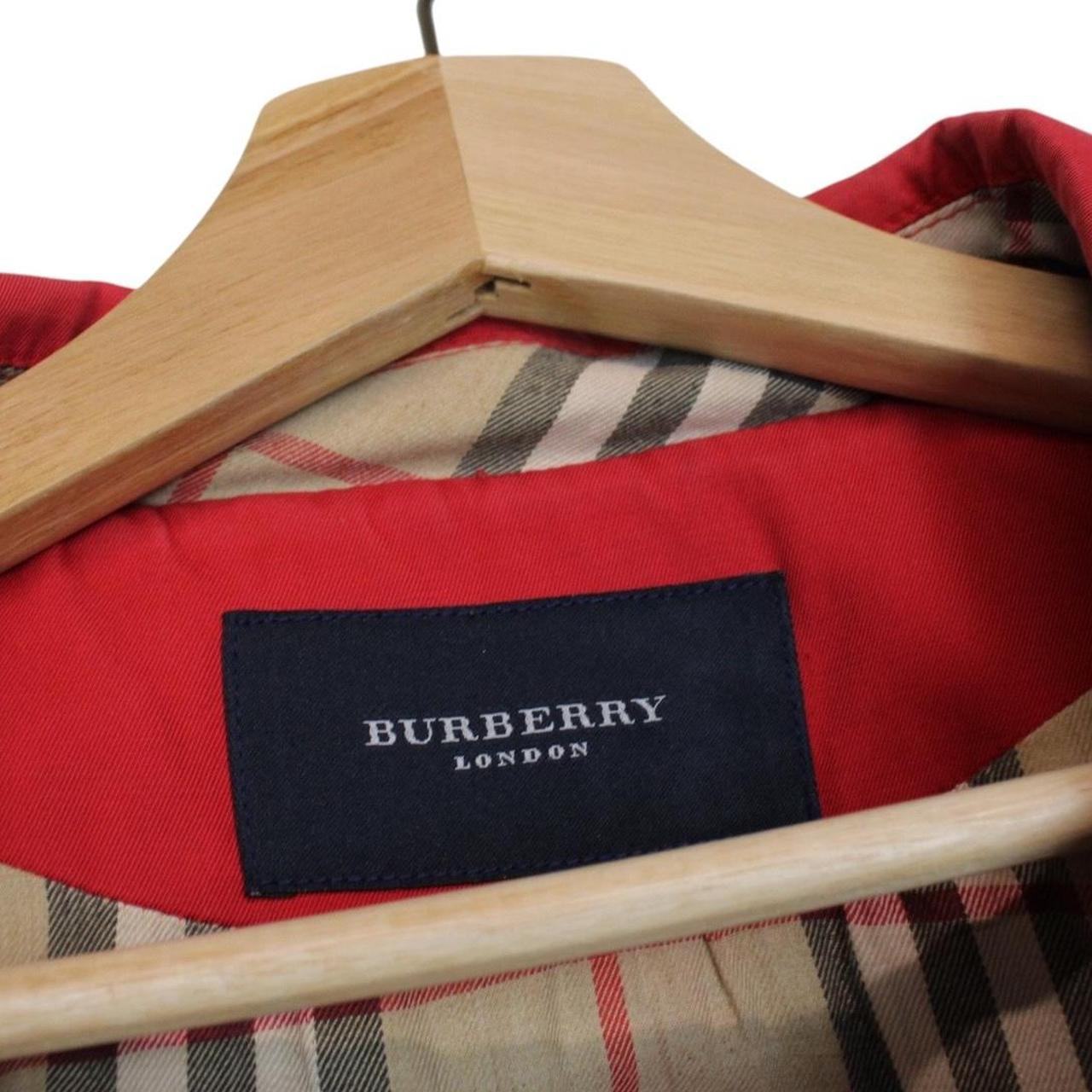 Burberry red trench coat with Nova Check pattern and belted waist detail.