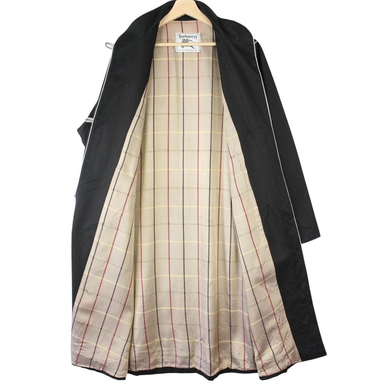 Burberry black cotton trench coat with single breasted design and classic logo detailing.