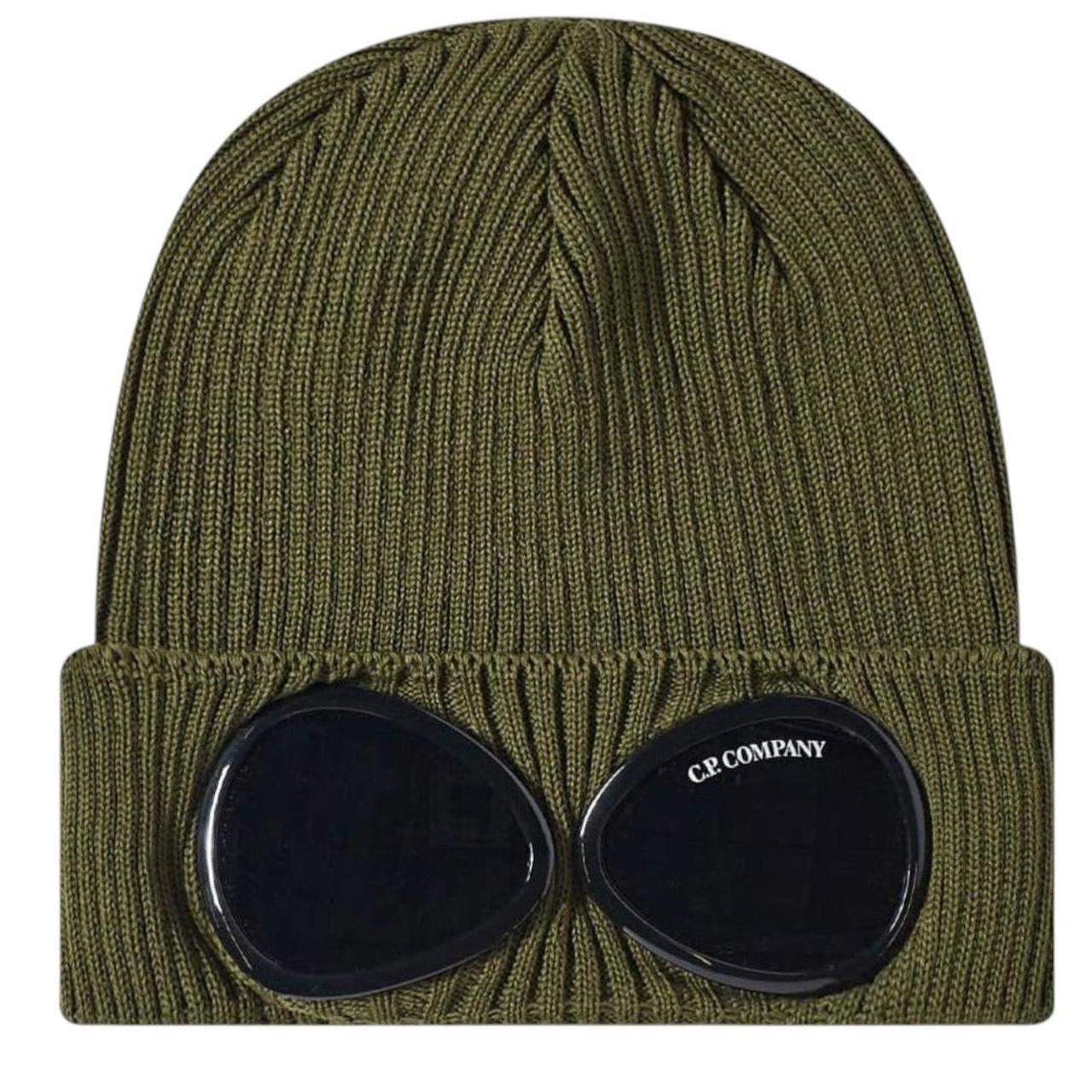CP Company green beanie hat with goggle detail and cotton material.