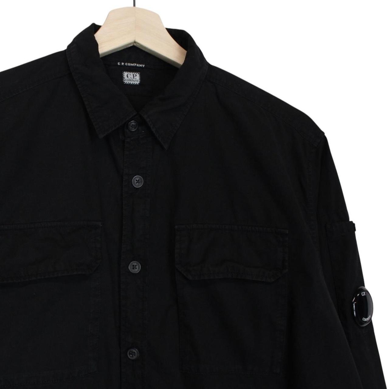 CP Company black button-up jacket with lens detail and cotton material.