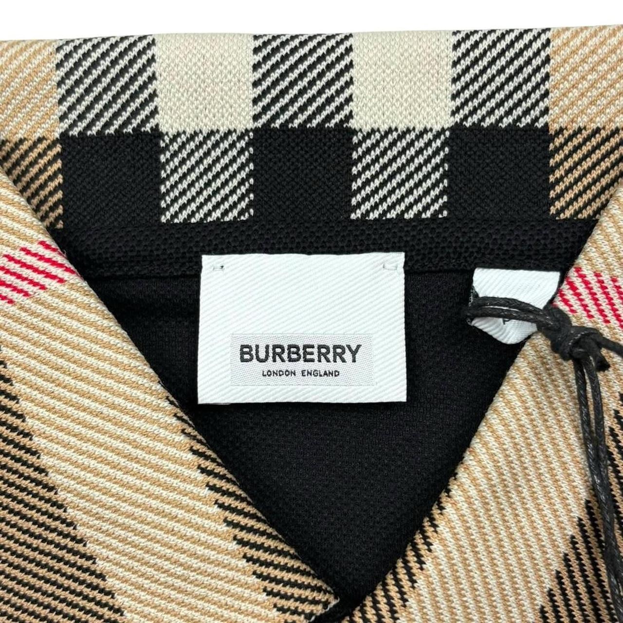 Burberry beige polo shirt with black Nova Check collar and cotton material.