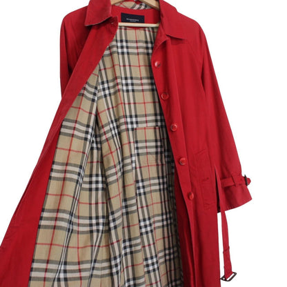 Burberry red trench coat with Nova Check pattern and belted waist detail.