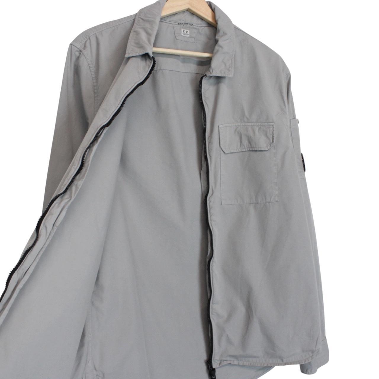 CP Company grey full zip overshirt jacket with lens detail and cotton material.