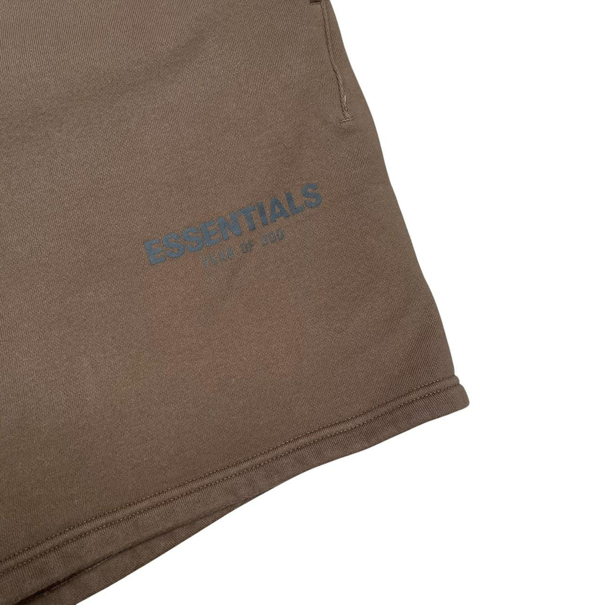 Essentials brown jogger shorts with logo detail and soft cotton material.