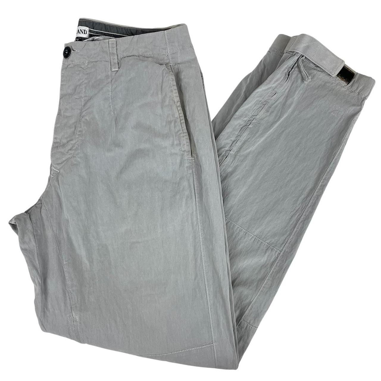 Stone Island grey tapered fit trousers with logo patch and cotton material.