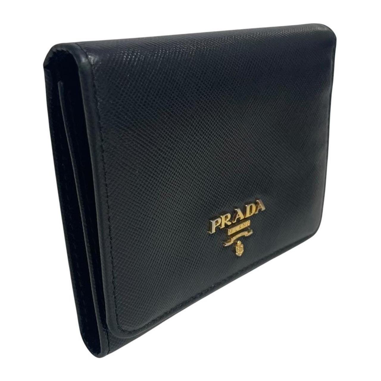 Prada black bifold wallet Saffiano leather with logo embossed detail.