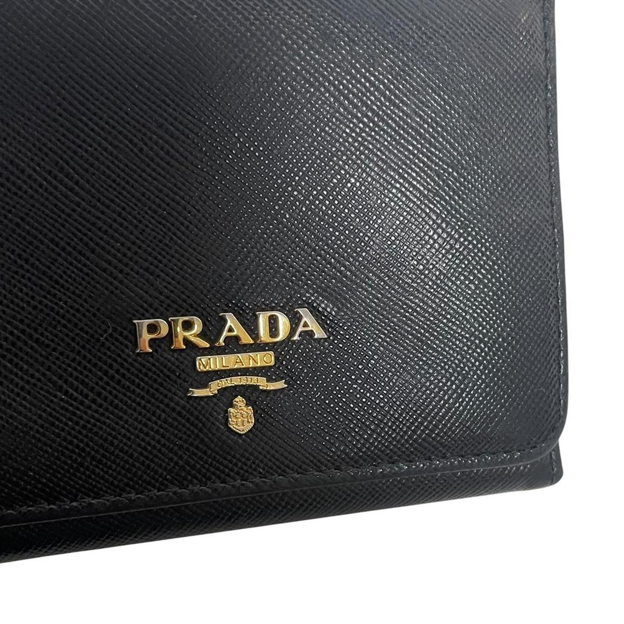 Prada black bifold wallet Saffiano leather with logo embossed detail.