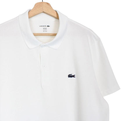 Lacoste white short sleeve polo shirt with green crocodile logo and cotton material.