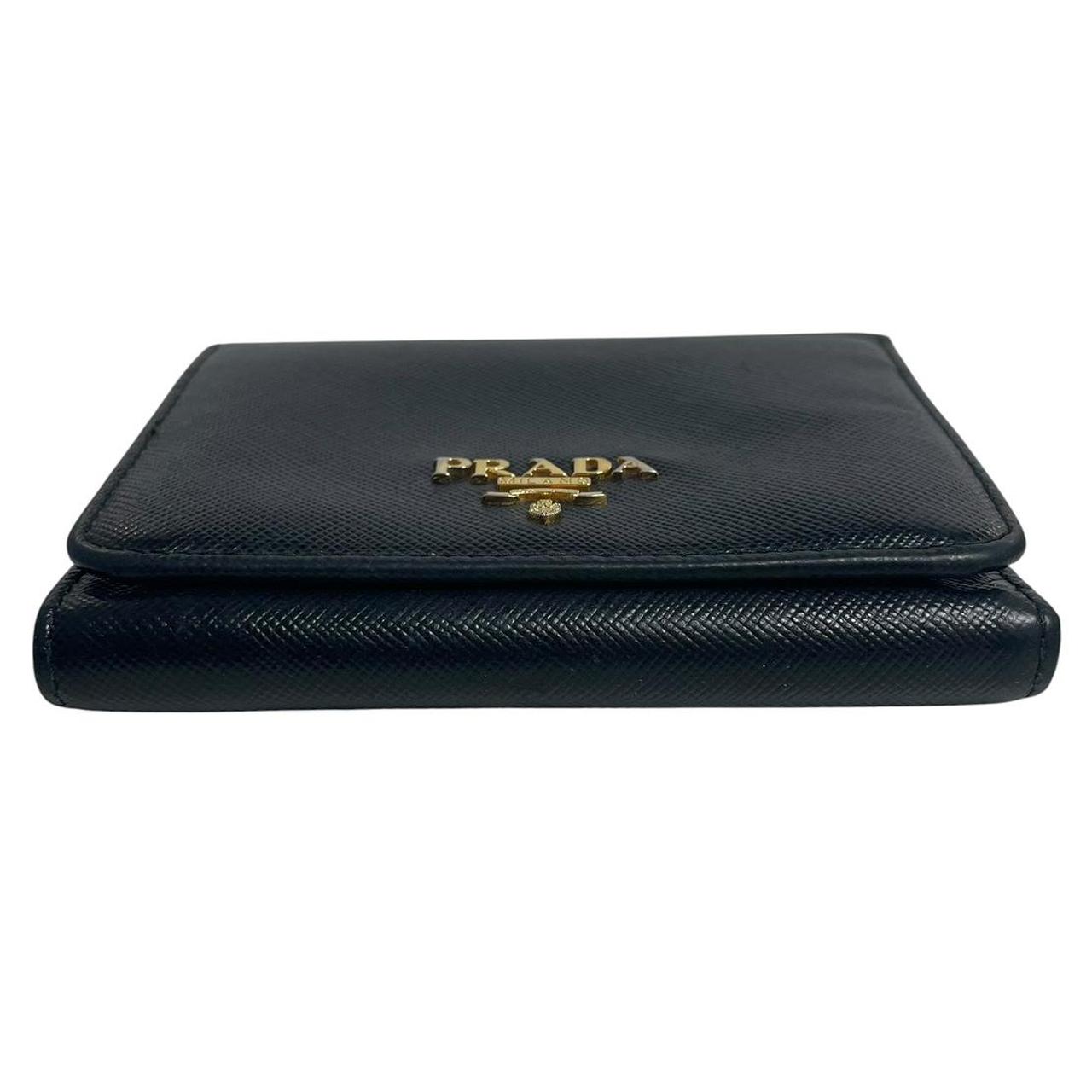 Prada black bifold wallet Saffiano leather with logo embossed detail.
