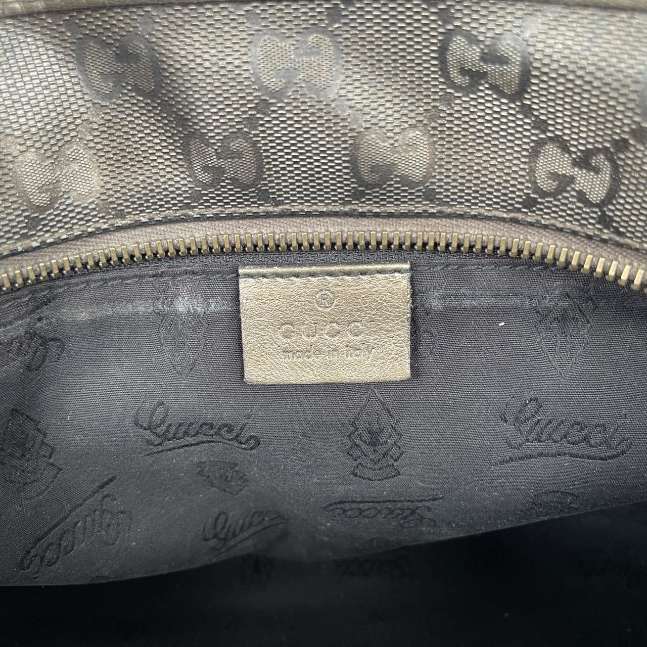 Gucci khaki green duffel bag with metallic monogram canvas and leather trim details.
