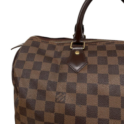 Louis Vuitton brown Damier Ebene canvas Speedy 35 bag with logo and gold-tone hardware.