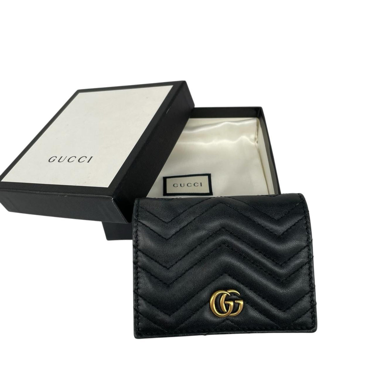 Gucci black calfskin wallet with matelassé pattern and GG logo detail.