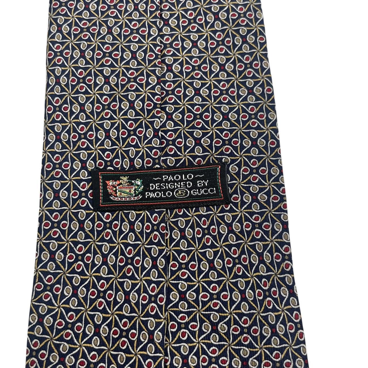 Gucci navy blue silk tie with vintage pattern and logo detail.