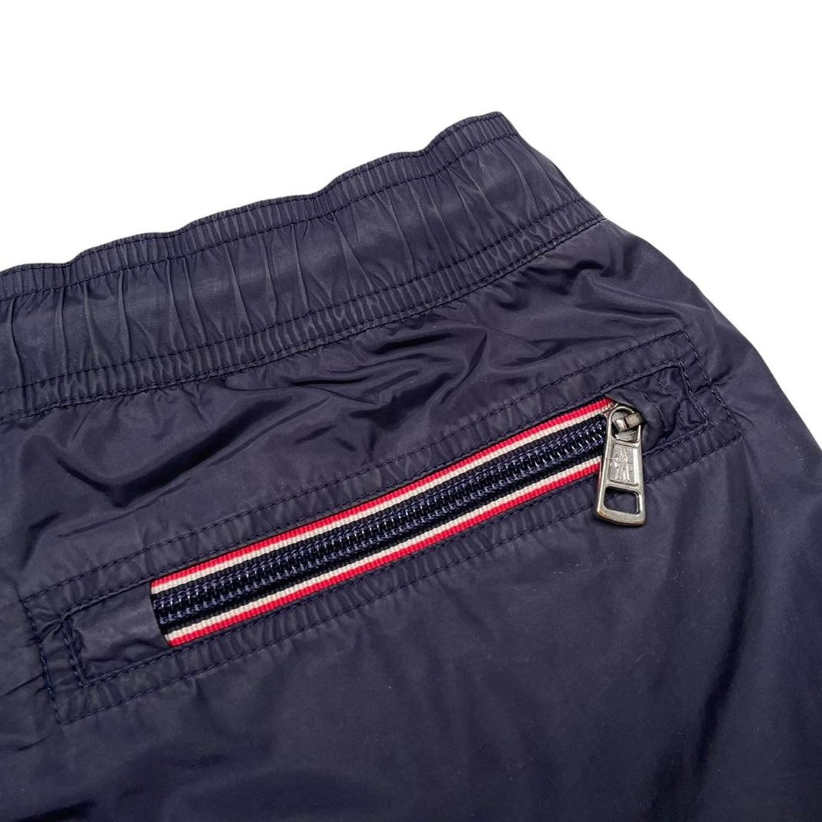 Moncler navy blue swim shorts with logo patch and lightweight nylon material.
