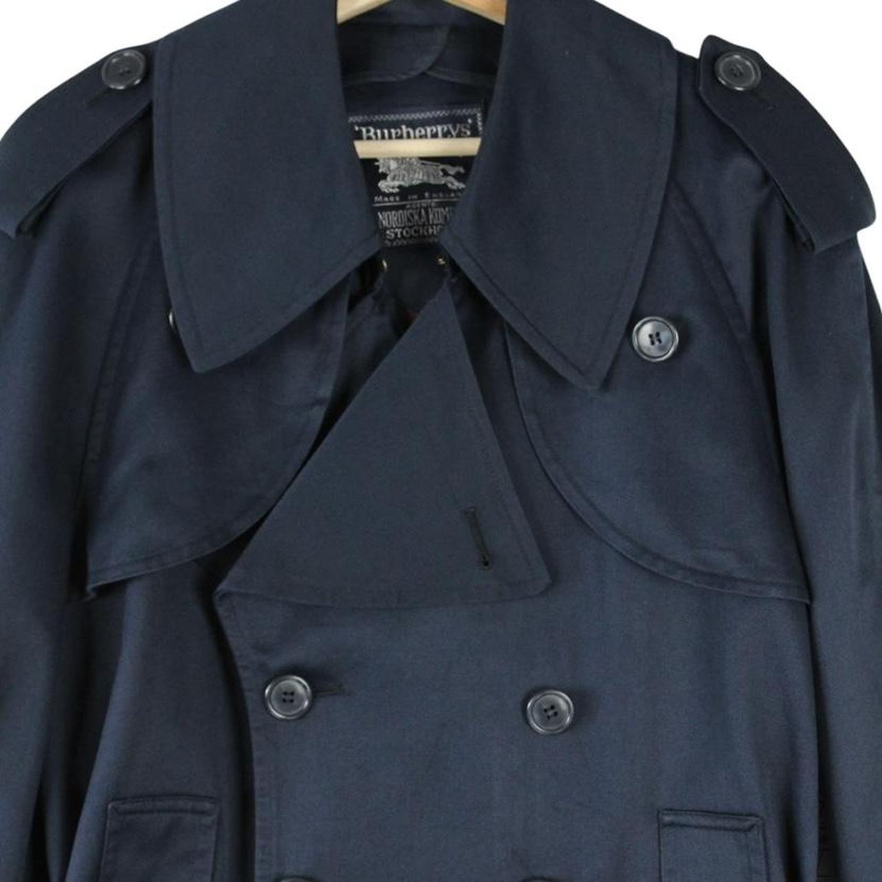 Burberry navy blue double breasted trench coat with belted waist and classic check lining.