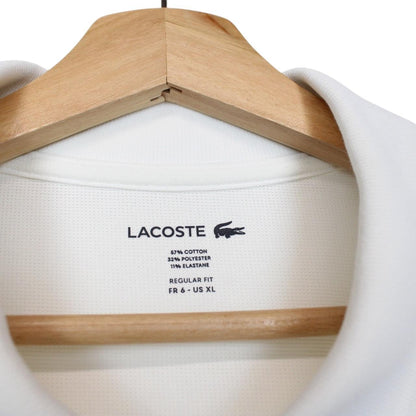 Lacoste white short sleeve polo shirt with green crocodile logo and cotton material.