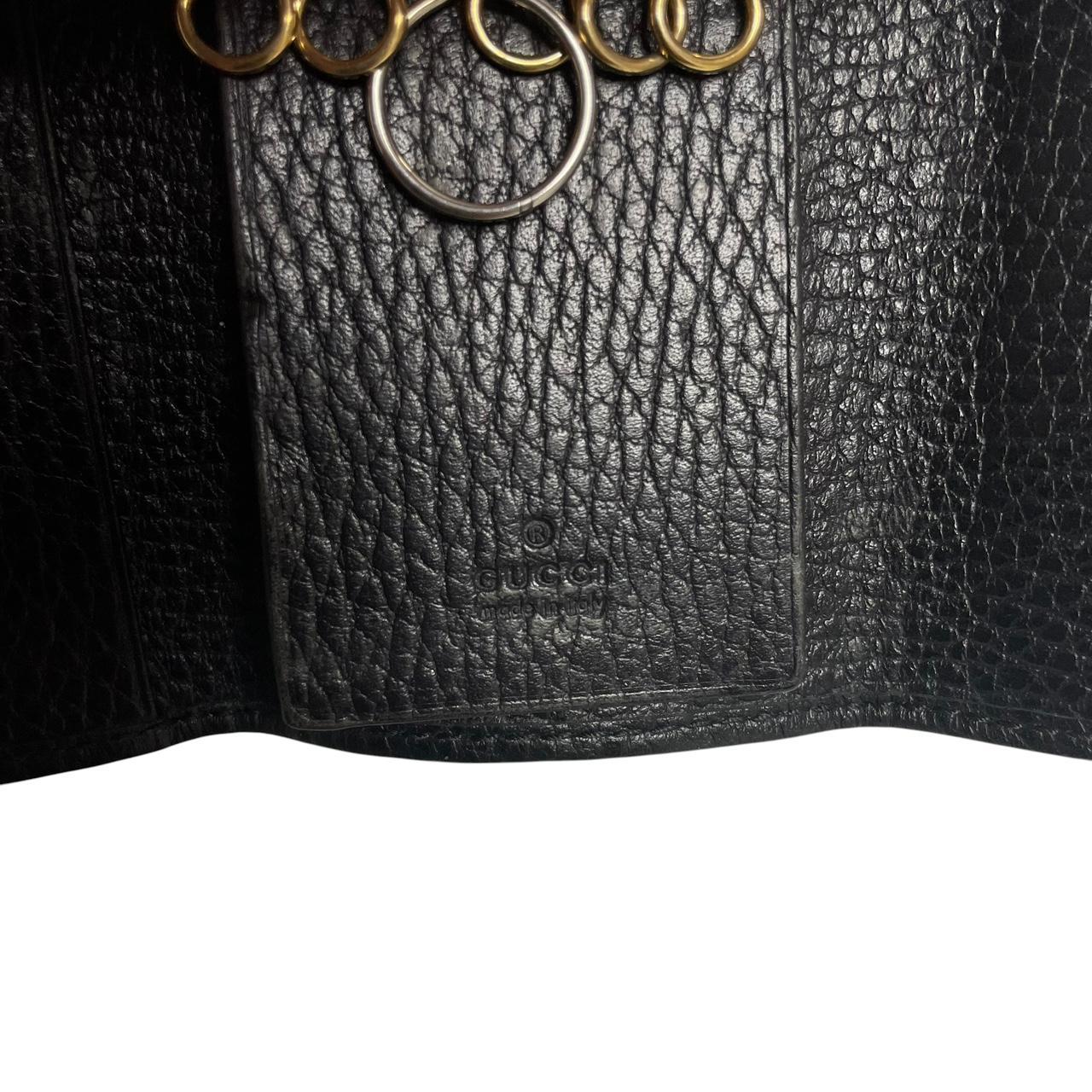 Gucci black leather key case with GG logo and quilted pattern.