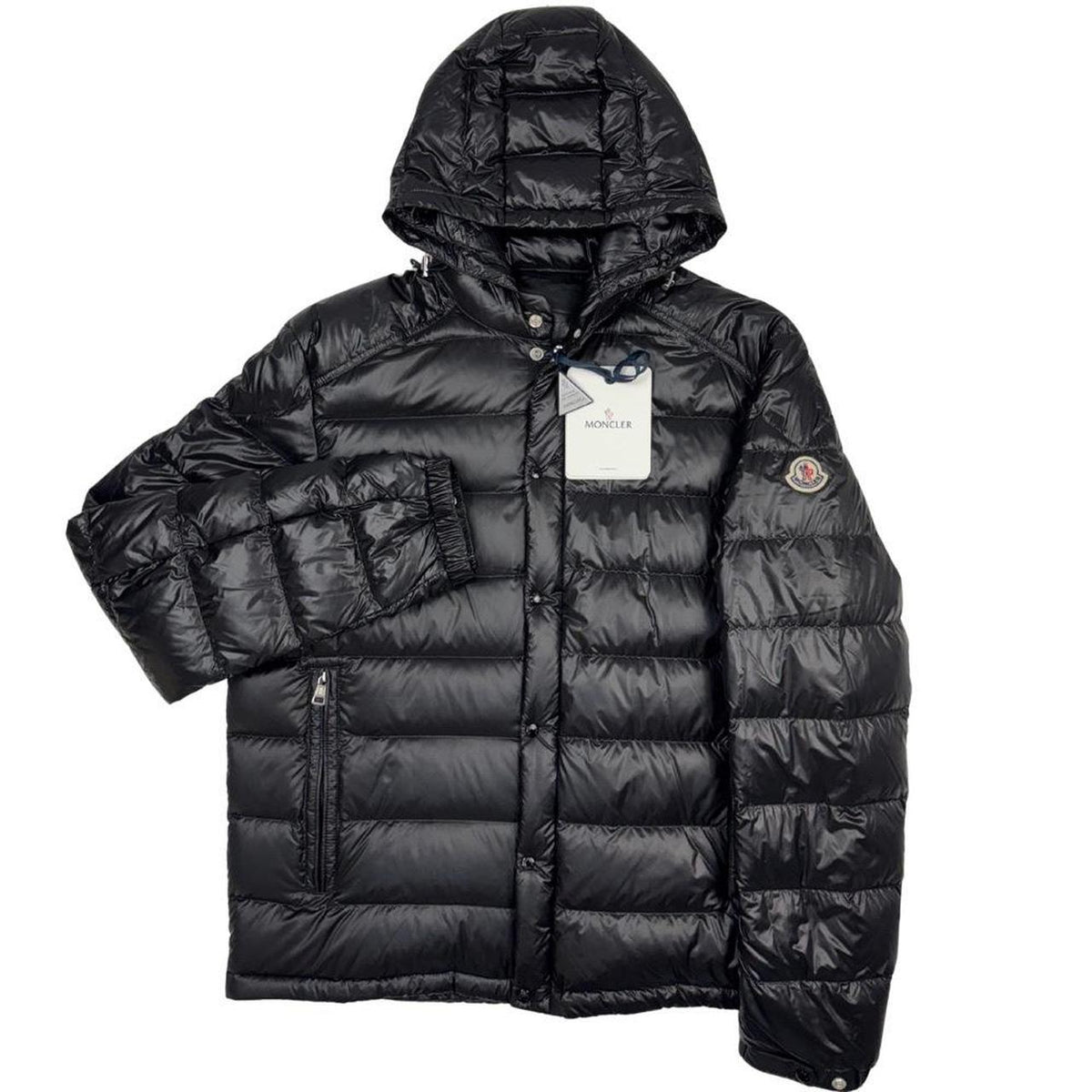 Moncler black hooded puffer jacket with logo patch and nylon material.