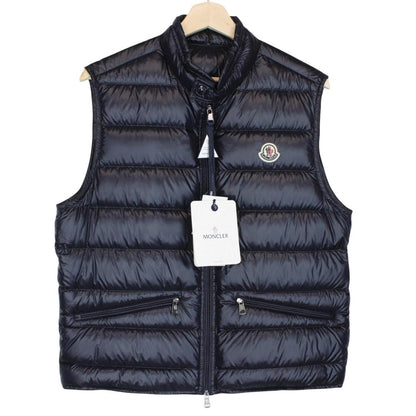 Moncler navy blue down gilet with logo patch and quilted design.