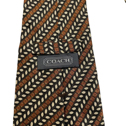 Coach brown floral print silk tie with intricate flower patterns and smooth texture.