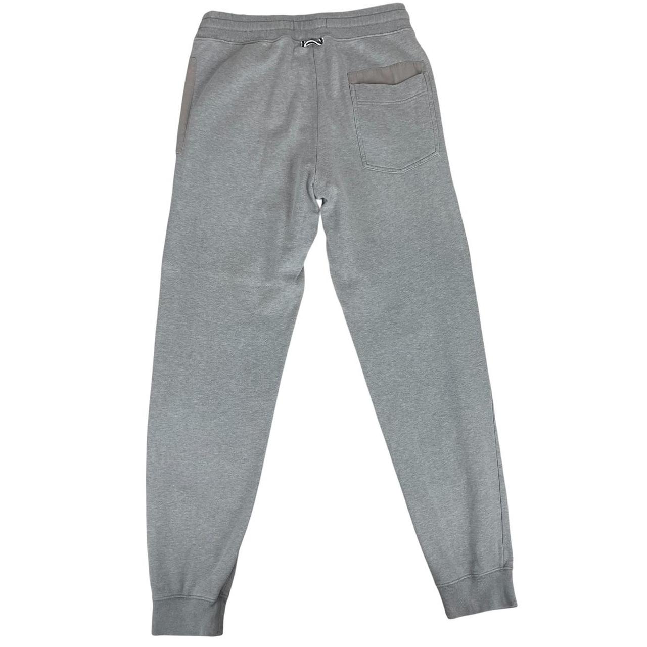 Stone Island grey tracksuit bottoms cotton material with logo patch and faint marks.