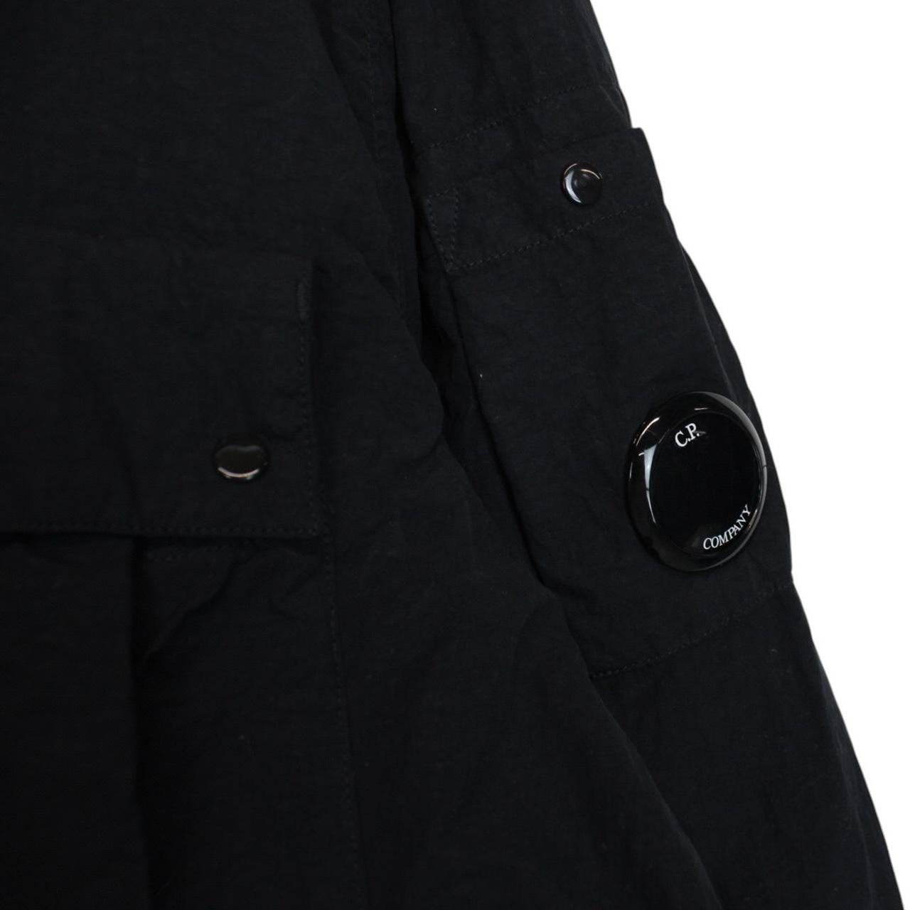 CP Company navy blue jacket 1/4 zip with lens detail and flat nylon material.