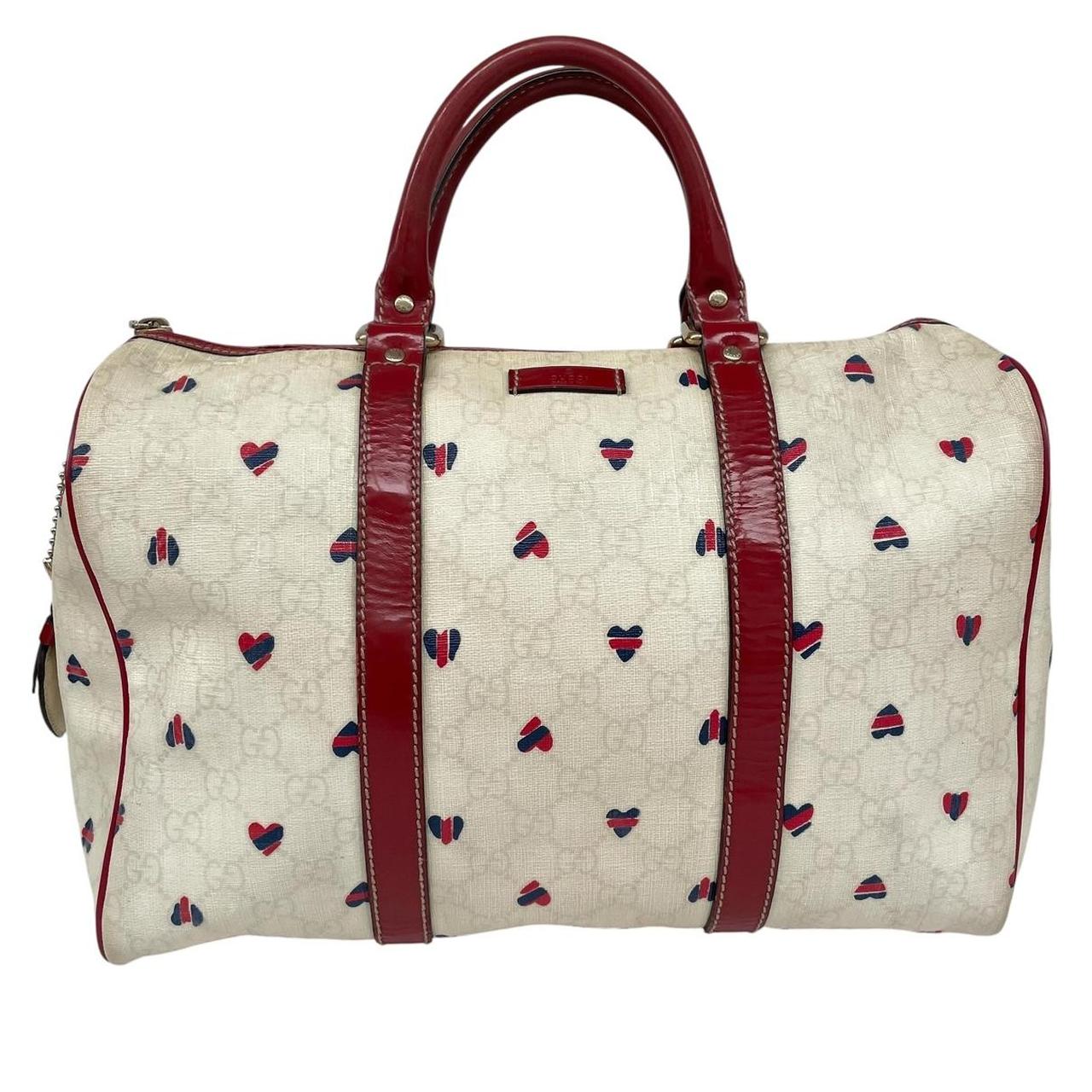 Gucci cream duffel bag with red monogram heart print and logo detailing.