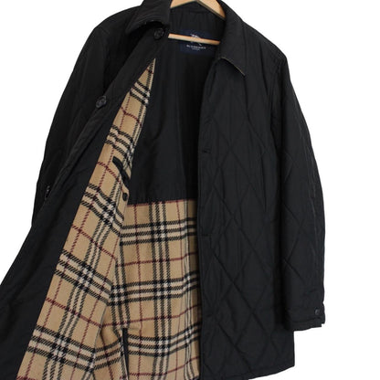 Burberry black coat with Nova Check lining and diamond quilted pattern.