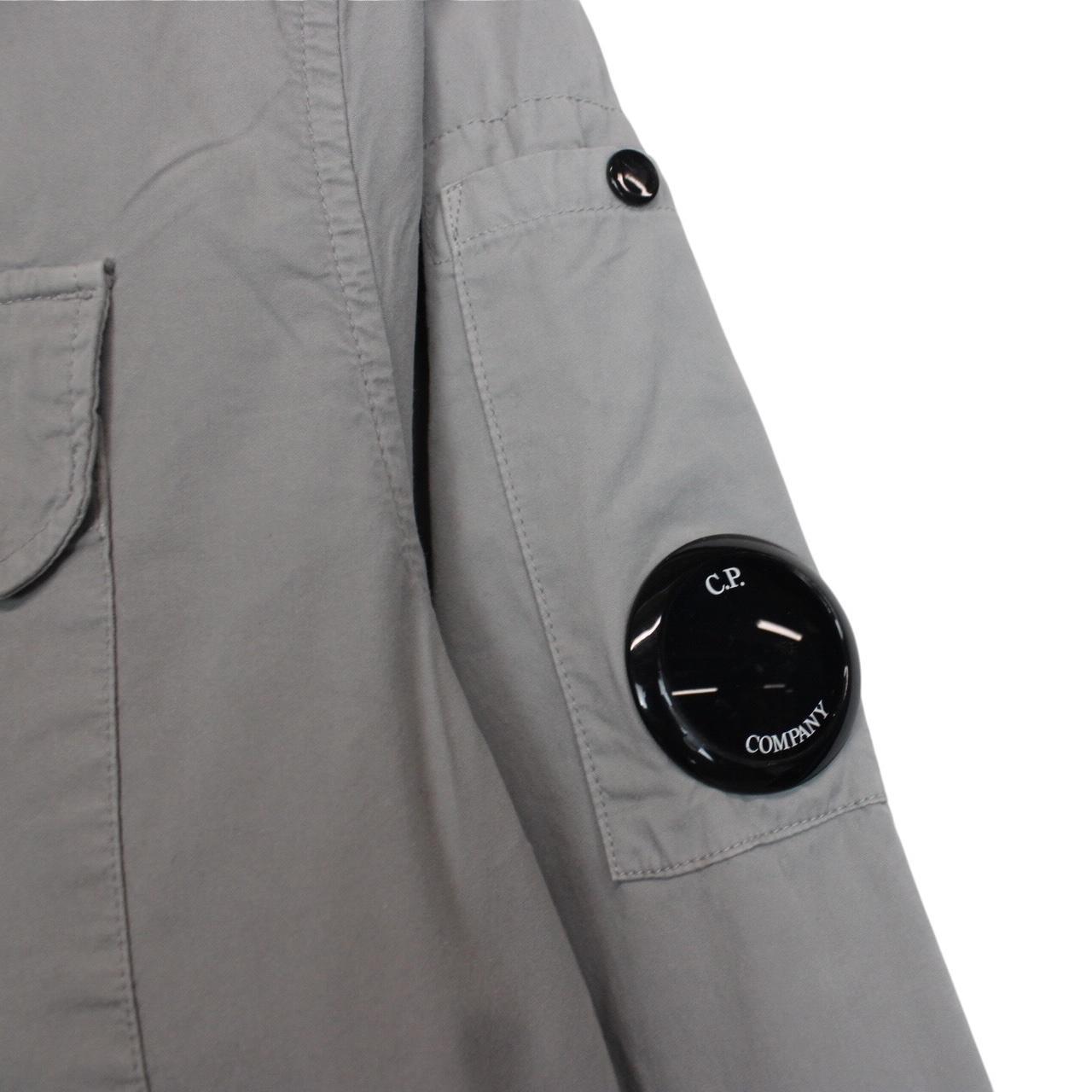 CP Company grey full zip overshirt jacket with lens detail and cotton material.