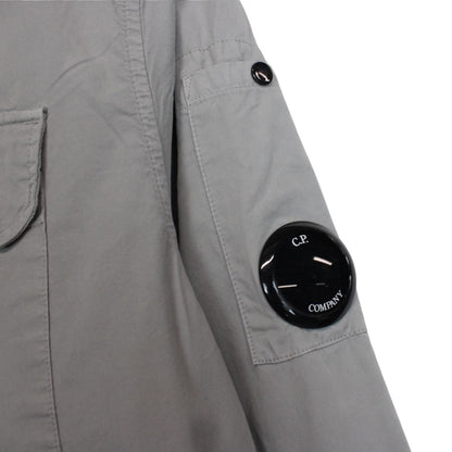 CP Company grey full zip overshirt jacket with lens detail and cotton material.