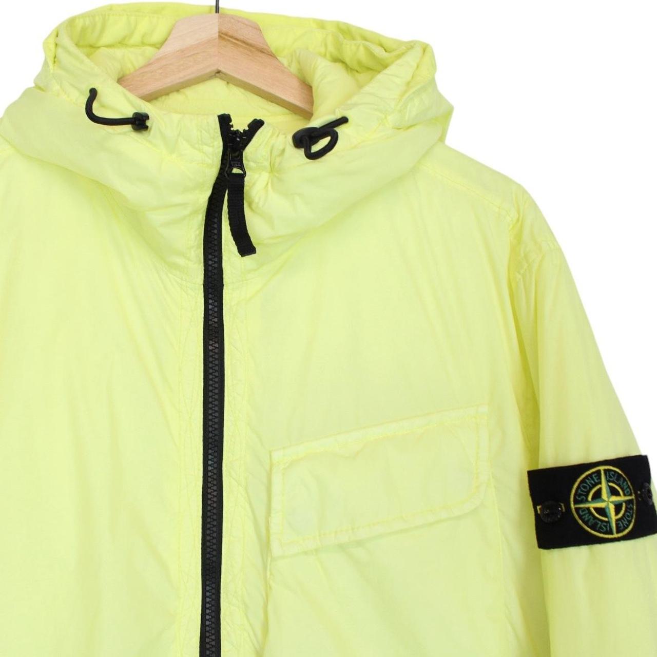 Stone Island yellow jacket with crinkle texture and logo badge on sleeve.
