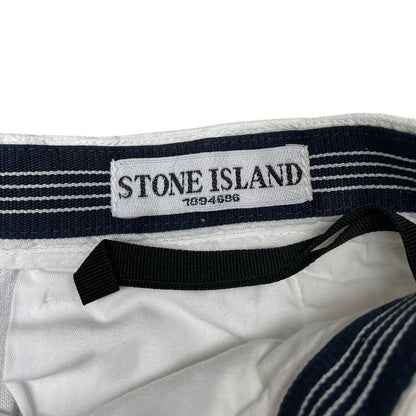 Stone Island white linen Bermuda shorts with logo patch and subtle stains.