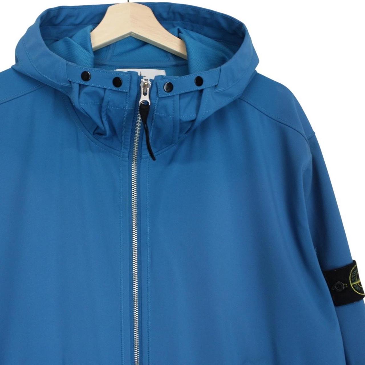 Stone Island blue full zip jacket with logo patch and soft shell material.